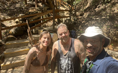 Guest enjoying volcanic mud facial treatment at Costa Rican hot springs resort with tropical garden backdrop - Macaws Adventure Tours by Pablo C